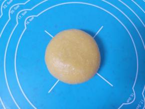 收口朝下摆放，用手掌轻轻压一下，一个南瓜蜜豆喜饼生胚就包好了。