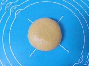 收口朝下摆放，用手掌轻轻压一下，一个南瓜蜜豆喜饼生胚就包好了。