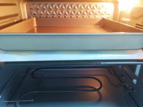 送入预热好的烤箱，上面盖上一层油纸，放上一个烤盘压着。