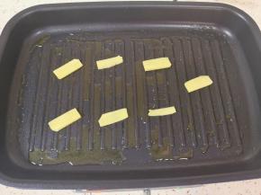 多功能锅放上浅盘预热，倒入适量的食用油，放上生姜片。