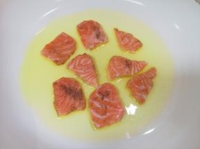 平底锅里倒多一点橄榄油，放入腌制好的三文鱼片。