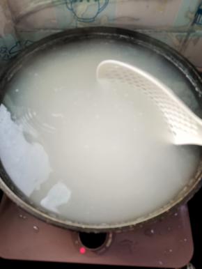 把淘洗干净的米倒入锅中，用漏勺推动几下，以免锅底黏住了！