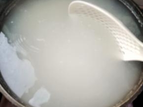 把淘洗干净的米倒入锅中，用漏勺推动几下，以免锅底黏住了！