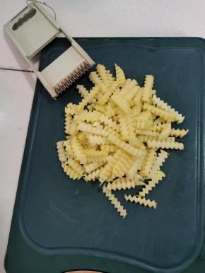 土豆削皮清洗干净，先切成厚片，再用擦丝器上自带的波浪刀，切成波浪形状的条！