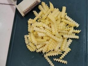土豆削皮清洗干净，先切成厚片，再用擦丝器上自带的波浪刀，切成波浪形状的条！