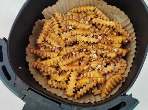 空气炸锅里铺一张油纸碗，把土豆倒进去，扒拉平！