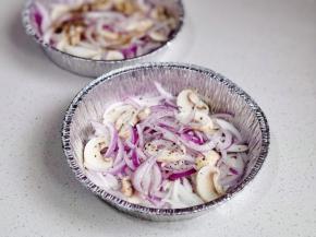 洋葱口蘑摆入锡纸碗中，撒黑胡椒，喷橄榄油。