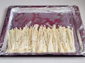 金针菇洗净摆入烤盘中，撒上黑胡椒。