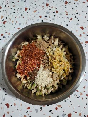 萝卜条中放入蒜末，细辣椒面，粗辣椒面，花椒面，五香粉，白芝麻！