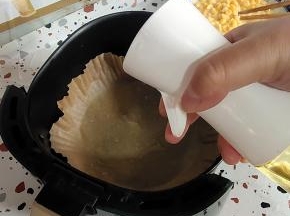 空气炸锅里铺一层油纸碗，再用喷壶喷适量的油！