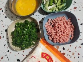准备好所需的食材:

葱头和葱叶分开切！葱叶切成葱花，葱头切成段！火腿肠切成小丁，准备两杯广东肠粉，再把鸡蛋打散备用！