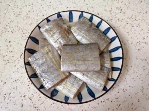 处理好的带鱼段放入盘子里，加入1勺料酒2勺生抽搅拌均匀，腌制15分钟左右。