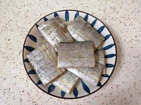 处理好的带鱼段放入盘子里，加入1勺料酒2勺生抽搅拌均匀，腌制15分钟左右。