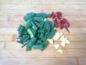 葱切成段，姜切成小片，干红辣椒从中间掰开。