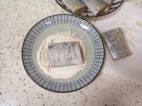 盘子里放入酥香炸粉，腌制好的带鱼段用厨房腌制吸干水分，表面裹上一层酥香炸粉。