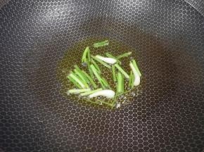 锅里继续倒油烧热，下入葱段炒出香味。