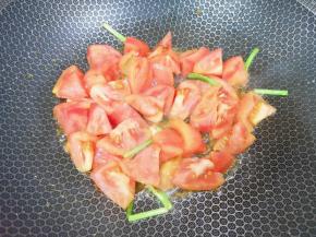 下入番茄块翻炒至出汁。