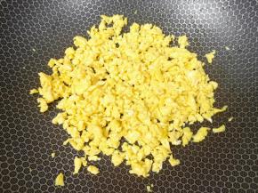 炒锅内倒适量的食用油烧热，倒入蛋液用筷子不停的搅动，将鸡蛋炒成碎粒状关火。