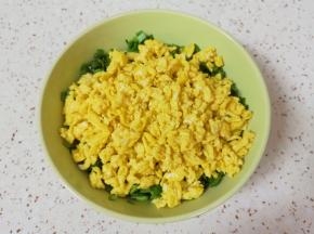 炒好的鸡蛋碎晾一下，倒入韭菜里面搅拌均匀。