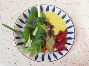 小葱打成结、生姜切成片，准备好八角、桂皮、香叶和干红辣椒。