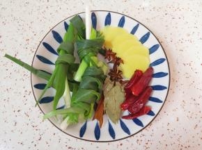 小葱打成结、生姜切成片，准备好八角、桂皮、香叶和干红辣椒。