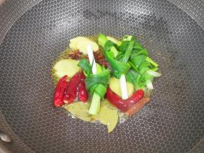 炒锅内倒适量的菜籽油烧热，下入葱结、姜片、八角、桂皮、香叶和干红辣椒炒香。