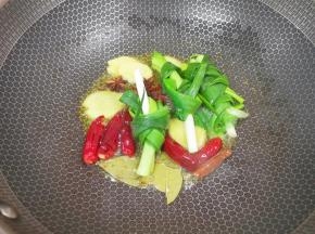 炒锅内倒适量的菜籽油烧热，下入葱结、姜片、八角、桂皮、香叶和干红辣椒炒香。