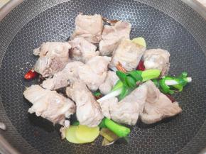 下入焯过水的大骨头翻炒至表面微微焦黄。