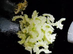 锅中余油爆香姜蒜，倒入苦瓜翻炒均匀。