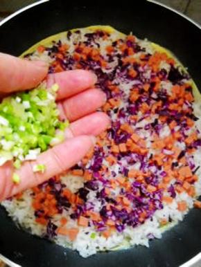 撒上火腿丁、甘蓝碎，加入香葱粒，小火煎透。