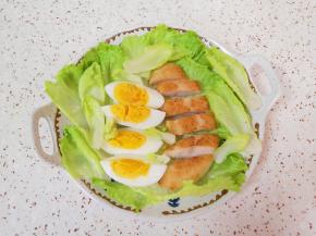 生菜心洗干净控一下水分，铺在盘子底部，放上切好的鸡蛋和鸡排。