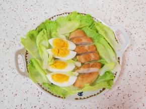 生菜心洗干净控一下水分，铺在盘子底部，放上切好的鸡蛋和鸡排。