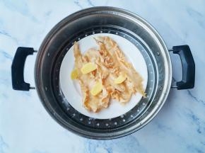 然后花胶上加3片姜、蒸锅水中滴几滴料酒，上锅蒸十分钟左右，取出放冰箱冷藏一晚上。