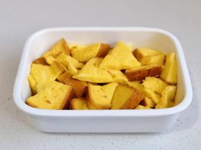 蛋液淋在吐司块中，每块吐司均匀裹上蛋液。