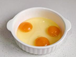 鸡蛋磕入碗中。