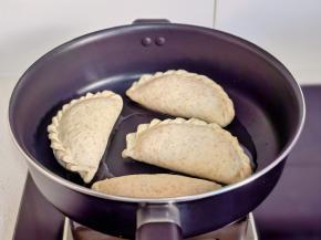 锅中热油，摆入韭菜盒子饼胚。