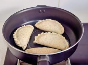 锅中热油，摆入韭菜盒子饼胚。