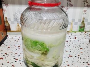 晾至温热，倒进玻璃瓶里！要多倒一点，面粉水要完全把白菜淹没住，不让白菜接触到空气，这样就不会腐烂变质！