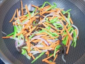 下入胡萝卜和木耳丝翻炒均匀。
