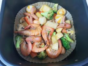 空气炸锅炸篮里铺上油纸，倒入拌好的食材，170度空炸13分钟，中间翻一次。