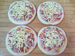  5分钟以后取出烤好的饼底，抹上一层番茄酱，撒上少许马苏里拉芝士，放上豌豆、玉米粒、红萝卜丁、洋葱和培根肉，最后再撒上一层马苏里拉芝士，晾凉以后用保鲜袋装好冷冻保存，下次想吃的时候直接烤就可以。