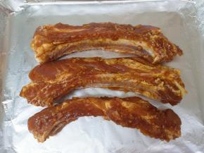 烤盘里铺上锡纸，刷上一层玉米油，放上腌制好的肋排条。