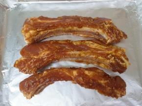 烤盘里铺上锡纸，刷上一层玉米油，放上腌制好的肋排条。