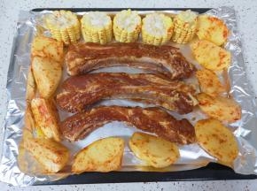 摆上土豆块和玉米，给玉米上面刷上一层土豆块的腌料。