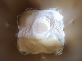 再加入高筋面粉、奶粉和细砂糖，面粉中间挖个小窝放入干酵母盖起来。