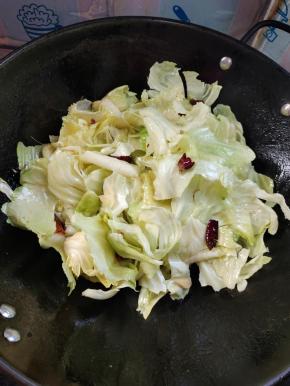 放入撕碎的包菜炒软！