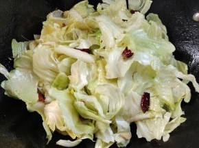 放入撕碎的包菜炒软！