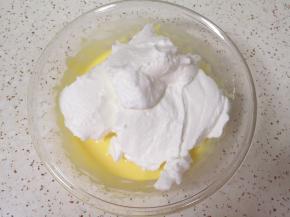 打发好的蛋白分成三份，取中间的三分之一加入到蛋黄糊里面，用硅胶刮刀采用切拌和翻拌的方法混合均匀。烤箱上下管150度预热。