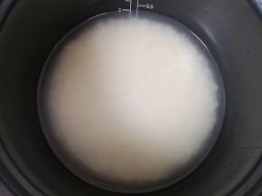 大米淘洗干净放入电压力锅饭煲内胆里面，按照比例加入纯净水，浸泡备用。