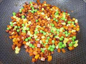 下入豌豆和玉米粒翻炒均匀。